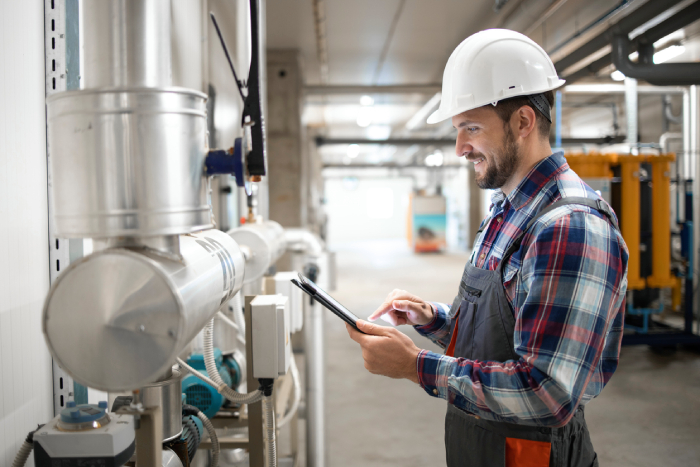 Operator working calmly in a factory holding a tablet